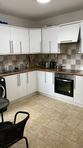 a kitchen with white cabinets and a stove at 305 High Town Road in Luton