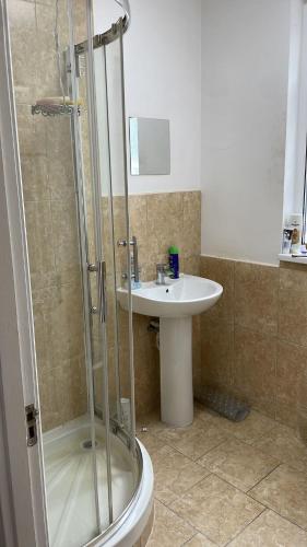 uma casa de banho com um chuveiro e um lavatório. em 305 High Town Road em Luton
