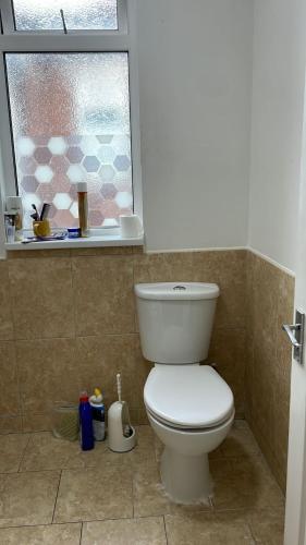 uma casa de banho com um WC e uma janela em 305 High Town Road em Luton