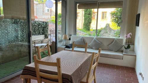 comedor con mesa, sillas y ventana en Pis amb molt d'encant al centre d'Olot en Olot