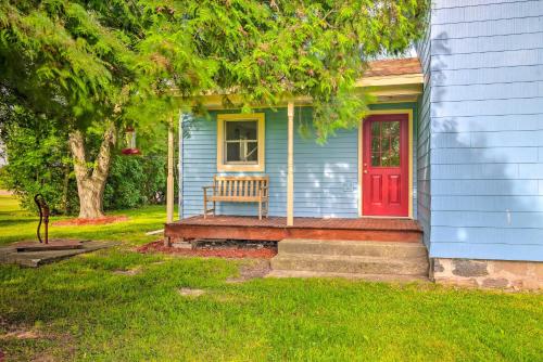 a blue house with a red door and a bench at Charming Stanley Home with Yard, 7 Mi to Seneca Lake in Geneva