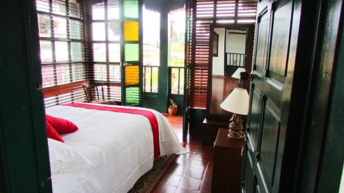 a bedroom with a bed in a room with windows at Casa La Carolina in Villa de Leyva