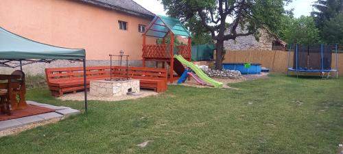 a yard with two benches and a playground at Sweet Home Apartman Szilvásvárad in Szilvásvárad