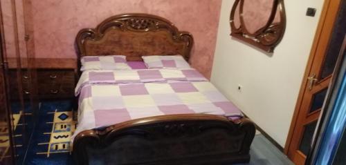 a small bedroom with a bed with a checkered blanket at Central City Park in Bacău