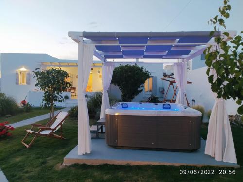 una bañera de hidromasaje bajo un cenador en un patio trasero en GeoNi's villa & garden spa, en Apollonia