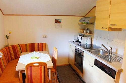 a small kitchen with a table and a sink at Atterseeblick - Ferienwohnung Anneliese Kunert in Wildenhag