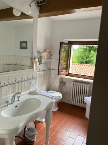 a bathroom with a sink and a toilet and a window at Dimora Rosa Bianca in Macerata