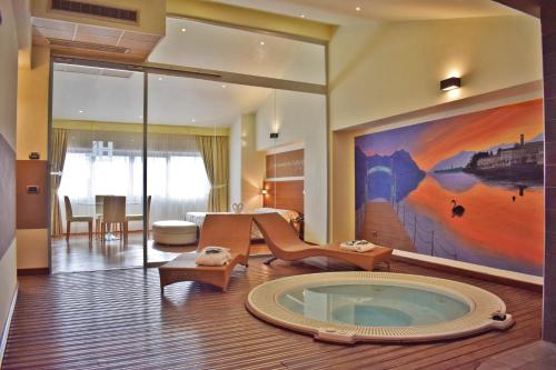 un soggiorno con vasca idromassaggio al centro della stanza di Hotel Lovere Resort & Spa a Lovere