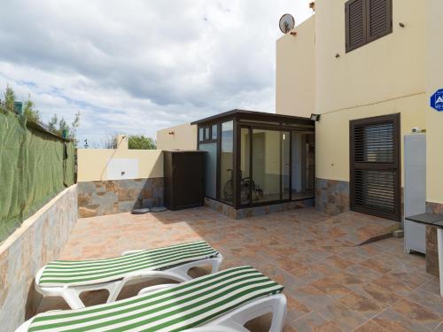 Vv Casa Maruca Accesibilidad - Playa 5 min في كاليتا ذي فوستي: فناء مع كرسيين للاستلقاء على فناء من الطوب