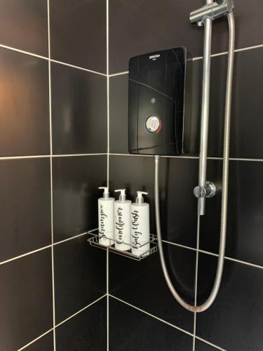 uma casa de banho com duche e 4 frascos de champô numa prateleira em Stylish apartment in the heart of Inverness em Inverness
