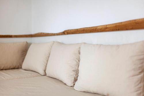 a white couch with pillows against a white wall at Alex & Sofi Hotel in Himare