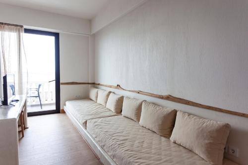 a couch in a living room with a large window at Alex & Sofi Hotel in Himare