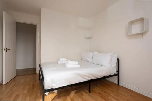 Bett mit weißer Bettwäsche und Kissen in einem Zimmer in der Unterkunft Stylish 2 Bedroom Apartment near the City Centre in Edinburgh