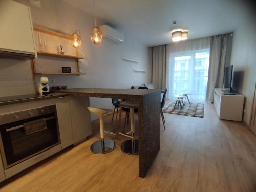 a kitchen with a table and a living room at Castle Town Apartment in Kaunas