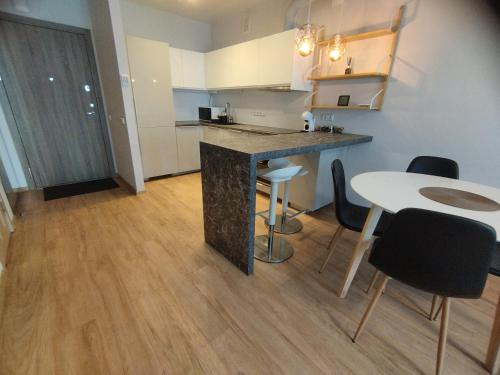 a kitchen with a counter and a table and chairs at Castle Town Apartment in Kaunas