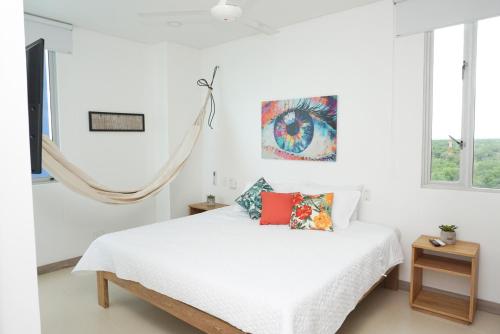 1 dormitorio con 1 cama con sábanas y almohadas blancas en Magico Apartamento Frente al Mar 3 Habitaciones PAZ282, en Coveñas