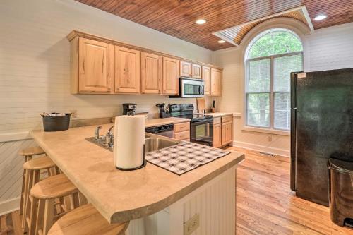 a kitchen with wooden cabinets and a black refrigerator at Bring Your Dog Blue Ridge Mountain Sanctuary! in Banner Elk