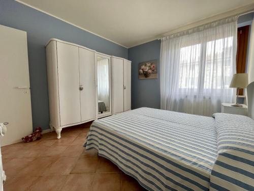 een slaapkamer met een bed en een witte kast bij Sweet Sunset Lazise in Lazise