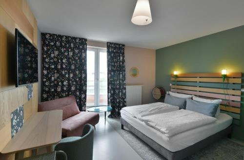 a bedroom with a bed and a couch and a table at Hotel BIRGIT Berlin Mitte in Berlin