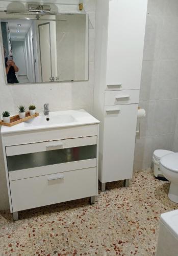 Baño blanco con lavabo y aseo en Habitaciones a dos pasos del congreso, en Elche