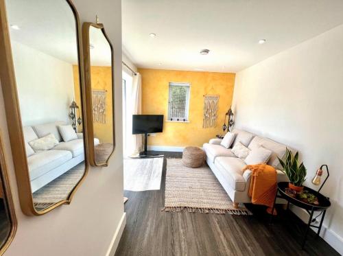 ein Wohnzimmer mit einem weißen Sofa und einem Spiegel in der Unterkunft Windsor, LEGOLAND, Ascot & Windsor RACECOURSE sleeps 3 in Windsor