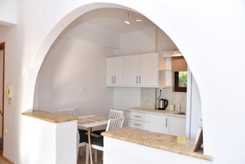 an archway in a kitchen with white cabinets and a table at Prana's Castle in Kyparissia