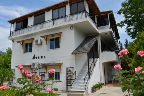 a white house with a balcony and pink flowers at Hotel Aroma in Përmet