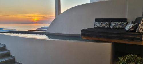 a couch sitting on a wall with a view of the ocean at Galaxy Suites & Villas in Imerovigli