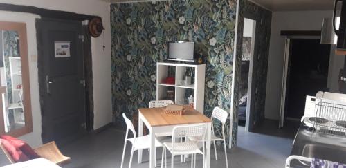 a dining room with a table and white chairs at Chez Claire de lune in Bolignies