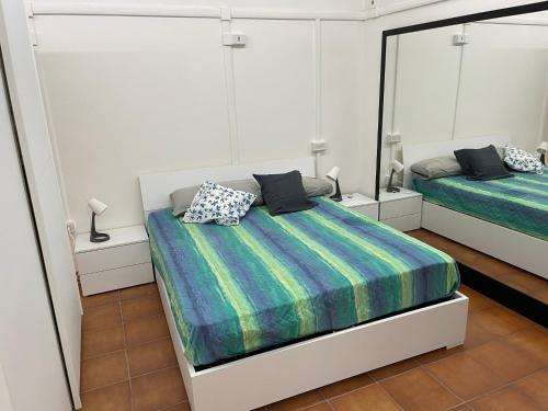 a bedroom with two beds and a mirror at Appartamento in Villa con giardino vicino al mare in Bella Farnia