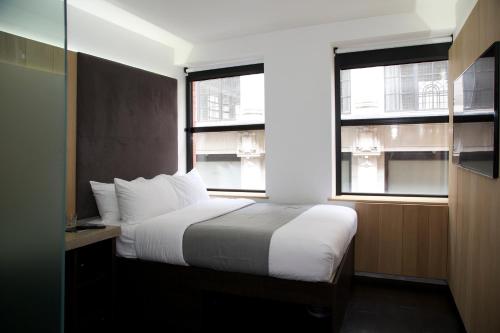 a bedroom with a bed and two windows at The Z Hotel Piccadilly in London