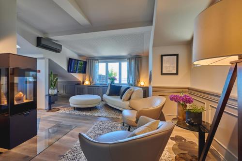 a living room with couches and chairs and a tv at Goldmädchen 93 - Honeymoon Suite in Timmendorfer Strand