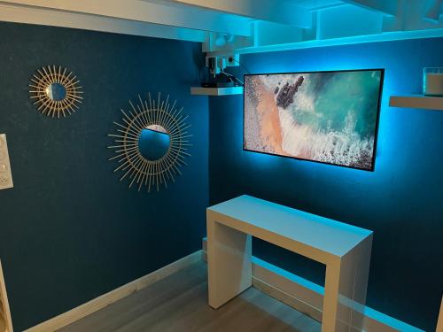 Cette chambre dispose d'un bureau et d'un mur bleu. dans l'établissement Superbe appartement à Proximité Plage et Port, au Cap d'Agde