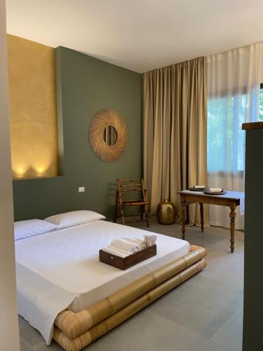 a bedroom with a large bed and a table at labotanica_casalounge in Cesenatico