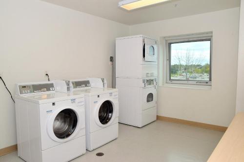 a laundry room with a washer and dryer and a window at Motel 6-Whitby, ON - Toronto East in Whitby
