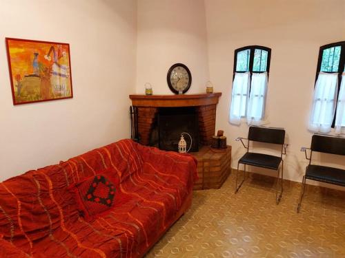 a living room with a red couch and a fireplace at Villa Anesis-Παραθαλάσσια βίλα in Amaliás