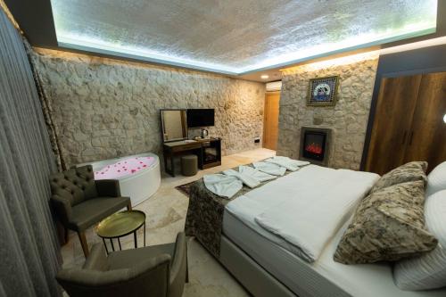 a bedroom with a large bed and a bath tub at Ahiyan Hotel in Uchisar