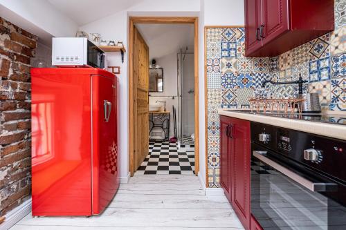 a red refrigerator in a kitchen with a checkered floor at Sarego PREMIUM Apartament in Kraków