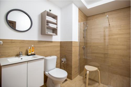 a bathroom with a toilet and a sink and a shower at CADORO City Center Apartments in Oradea