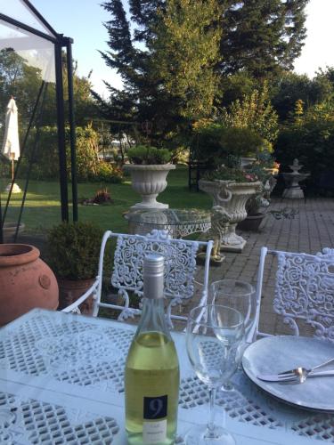 una botella de vino sentada en una mesa con copas en Dobbeltværelse i smuk palævilla, en Stenstrup