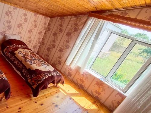 a bedroom with a bed and a window at La Casa de Habel in Quba