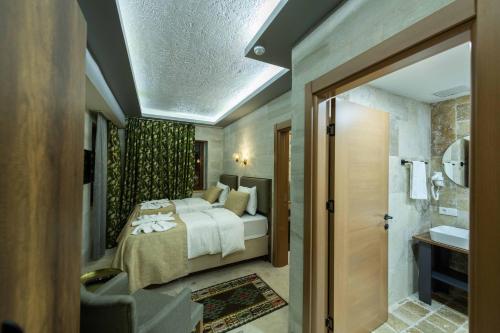 a bedroom with a bed and a bathroom at Ahiyan Hotel in Uchisar