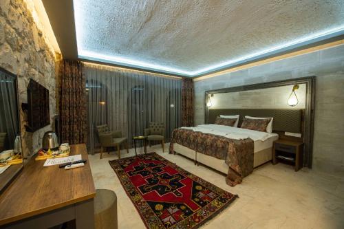 Habitación de hotel con cama, escritorio y habitación en Ahiyan Hotel en Uchisar