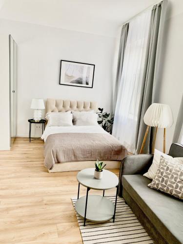 a bedroom with a bed and a couch and a table at Suites by Riga Old Town in Riga