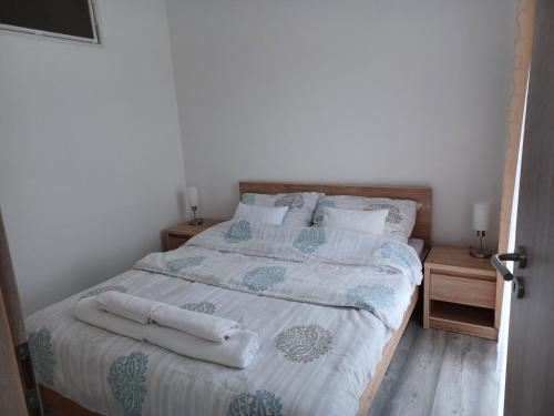 1 dormitorio con 1 cama con 2 toallas en To8 apartman, en Dunapataj