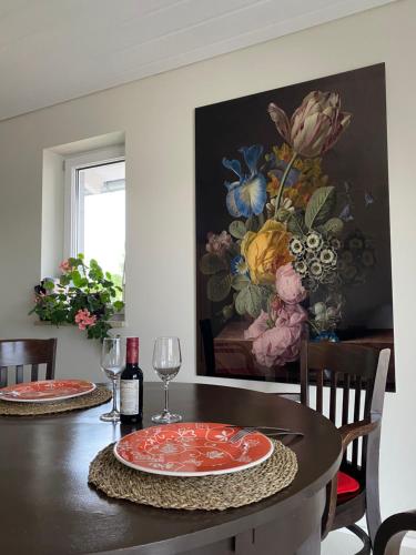 a dining room table with a painting on the wall at Petit Appartement in Hapberg