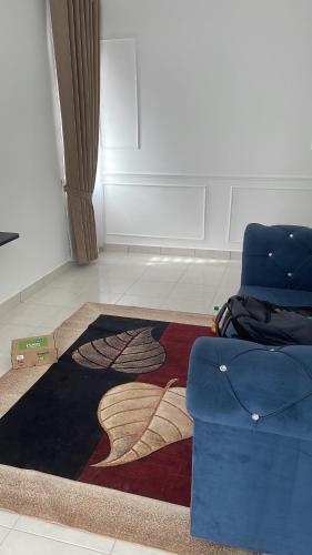 雙溪大年的住宿－Wan’ Homestay，一间铺有地毯并配有蓝色椅子的客房
