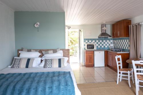 een slaapkamer met een bed en een keuken bij La Maison du Vieux Port in Flamanville