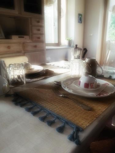 a table with a plate and a tea pot on it at Cascina Spazio Indaco in Castagnole Monferrato