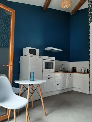 une cuisine avec des armoires blanches et un mur bleu dans l'établissement Laetitia et Yaniv Dagon, à Elne